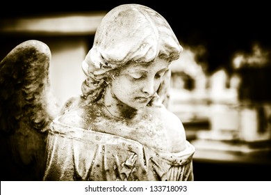 Vintage image of a sad angel on a cemetery with a diffused background - Powered by Shutterstock