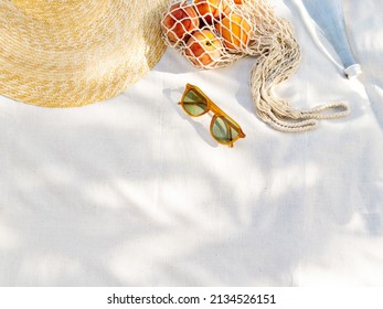 Vintage inspired background with straw hat, female sunglasses and shopper bag with peaches on white towel. Minimalist summer vacation creative still life ​for fashion blog, web, social media, stories. - Shutterstock ID 2134526151