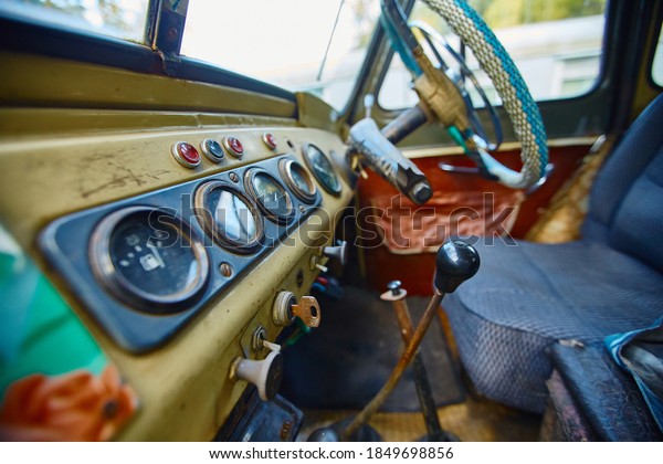 Vintage interior of an old car with a retro\
dashboard and steering wheel in a PVC\
cover