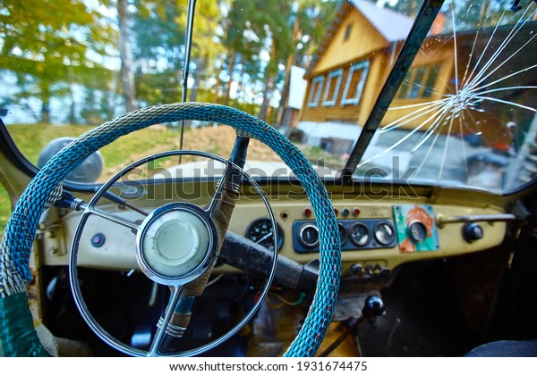 Vintage interior of an old car with a retro\
dashboard and steering wheel in a PVC\
cover
