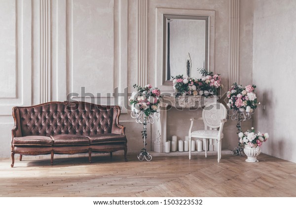 Vintage interior sofa with a vase of flowers in\
shabby chic style.