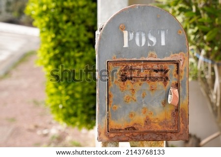 Vintage iron rusty post box on home wall old mailbox