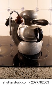 Vintage Italian Stovetop Atomic Espresso Coffee Maker On A Modern Black Glass Top Stove.