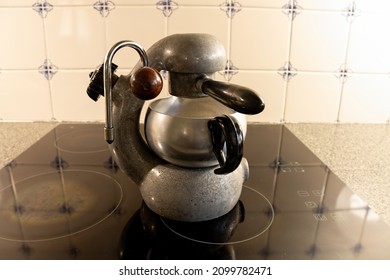 Vintage Italian Stovetop Atomic Espresso Coffee Maker On A Modern Black Glass Top Stove.