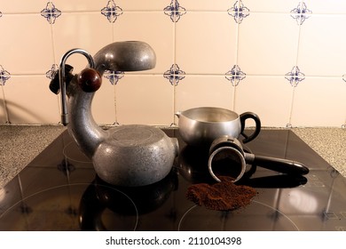 Vintage Italian Stovetop Espresso Coffee Maker On A Modern Black Glass Top Stove.