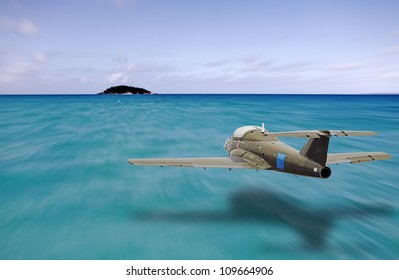 A Vintage Jet Plane Flying At Low Altitude Towards A Small Island In The Middle Of A Vast Blue Ocean.