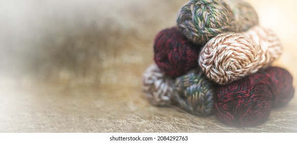 Vintage Knitting needles and yarn on wooden background. natural wool knitting background. knitting yarn for handmade winter clothes. Close Up of yarn balls. Rainbow colors.  Place for text, banner.