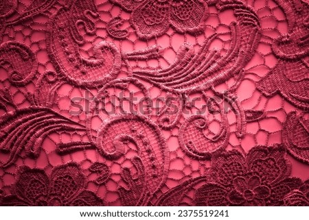 Vintage lace fabric with floral pattern, red background with lace pattern.