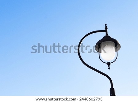 Vintage lamp post side street old lamp blue sky background in bright sunlight. Roadside lighting is necessary for road traffic night. Suitable for installation in area that require lighting.