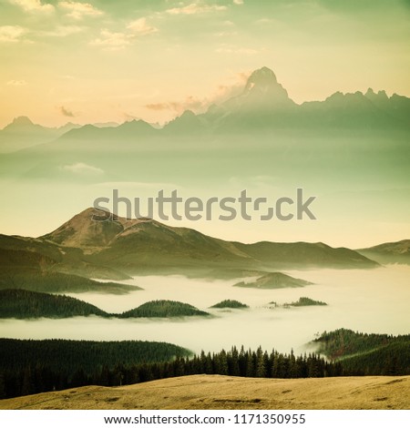 Vintage landscape with mountain peaks and mist, nature background, film filter