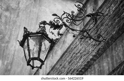Vintage lantern in Venice (Italy). Architectural detail. Retro aged photo with scratches. Black and white.