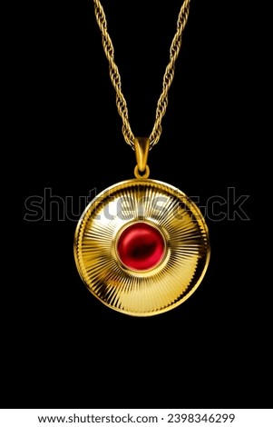 Vintage large golden pendant with ruby gem hanging on black background