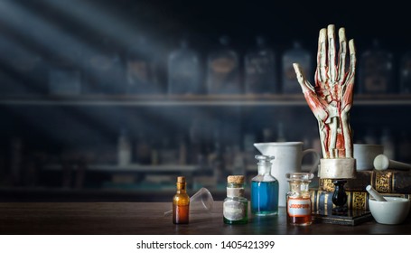 Vintage Layout Of A Man's Hand, Old Medical Glass Bottles, Antique Medical Tools On The Background Of A Medical Office. Old Medical, Education And Science Background.