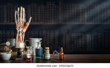 Vintage Layout Of A Man's Hand, Old Medical Glass Bottles, Antique Medical Tools On The Background Of A Medical Office. Old Medical, Education And Science Background.