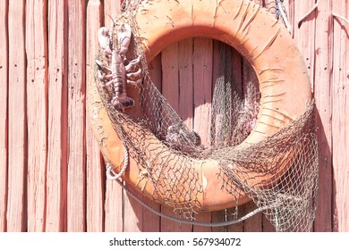 Vintage Life Preserver With Net Hanging On A Rustic Pink Wood Fence. Nautical Concept, Theme, Decor, Background.