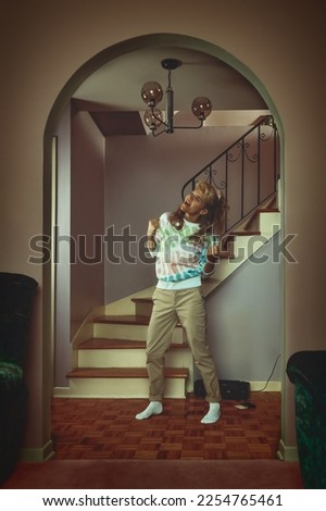 vintage lifestyle portrait of a young blonde woman in a late 80s, early 90s, interior decor, singing to music playing on a tape recorder in front of a staircase