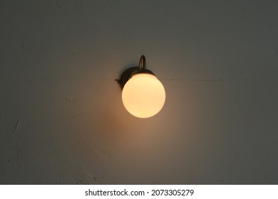 Vintage Light Bulb On The Wall In Low Light Room