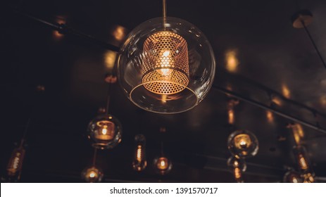 Vintage light fixtures fastened to the ceiling glass covering Edison light. Interior decoration bulbs electricity Los Angeles 2019 may gold tones bright inside electricity lightbulb