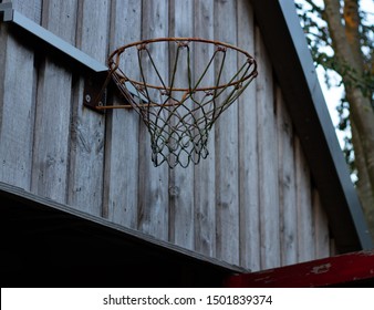 vintage looking basketball basket above the to an wooden garage