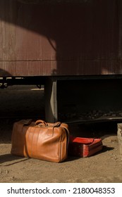 Vintage Luggage Bags Placed In Front Of An Old Brick Wall With A Retro Window And Cargo Train Cabin