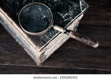 Vintage magnifying glass with books on wooden table