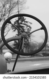 Vintage mechanical combustion engine farm tractor steering wheel in black and white.