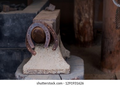 Vintage Metal Horseshoes Hanging On Anvil