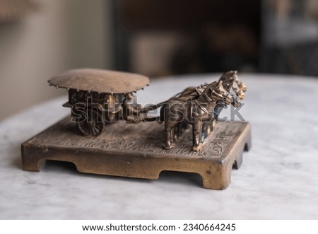 Vintage metal made miniature replica of  horse dependent transportation named chariot driven by a charioteer, a collectible item 