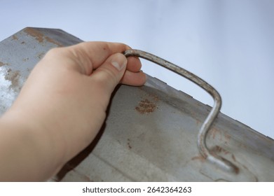 Vintage metal toolbox with rusty patina and embossed wrench design. Ideal for themes of repair, DIY, mechanics, handyman work, retro tools, and industrial style.