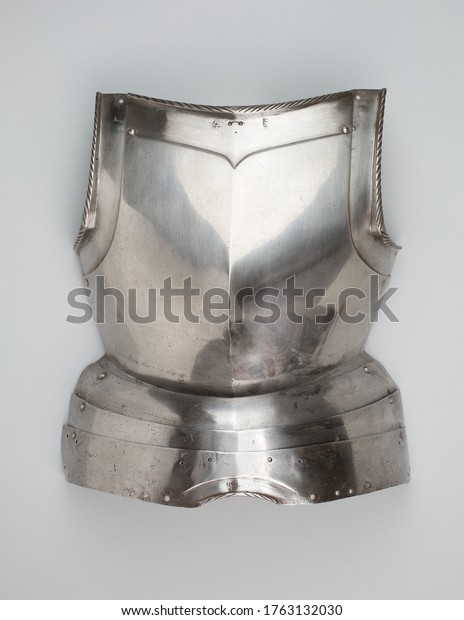 A vintage metal warrior breastplate isolated\
on a gray background