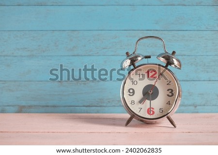 Vintage metallic 7.30 am alarm clock on pink and blue pastel wood