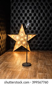 Vintage Microphone On Background Leather Walls And Star Illuminated