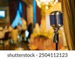 Vintage microphone on stage at a wedding reception venue. A vintage microphone stands ready as guests enjoy a wedding reception.