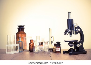 Vintage microscope and old laboratory glass retro style photo