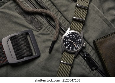 Vintage military watch and leather wallet on army green background, Classic timepiece mechanical wristwatch, Men fashion and accessories.