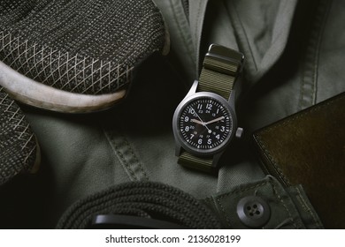 Vintage military watch and leather wallet on army green background, Classic timepiece mechanical wristwatch, Men fashion and accessories.