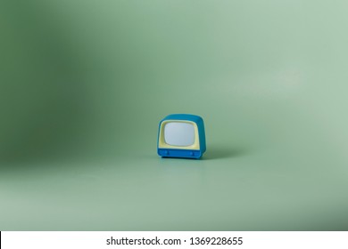 Vintage Miniature Tube TV Turned Off Toy Blue And White On Green Backround.