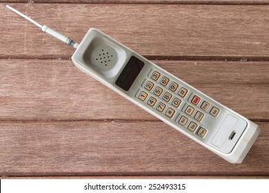 vintage mobile phone on brown wood  background.