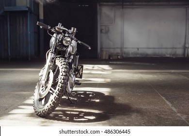 Vintage Motorcycle Standing In A Dark Building In The Rays Of Sunlight. Front View