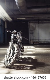 Vintage Motorcycle Standing In A Dark Building In The Rays Of Sunlight. Vertical Front View