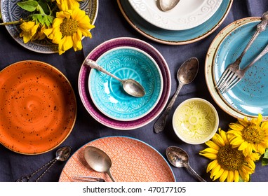 Vintage Multicolored Empty Plates And Bowls On A Dark Gray Linen Tablecloth With Sunflower. With Antique Spoons And Forks. Table Setting. Shabby Chic/retro Style. Top View. Rustic Kitchen