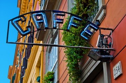 Vintage Neon Caffe (coffee) Sign Hanging Against Colorful Buildings In Rome, Italy