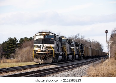 A vintage Norfolk Southern cargo train passing through the station