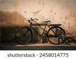 Vintage old bicycle leaning against dirty old wall background. Classic bike on decay wall with retro style.