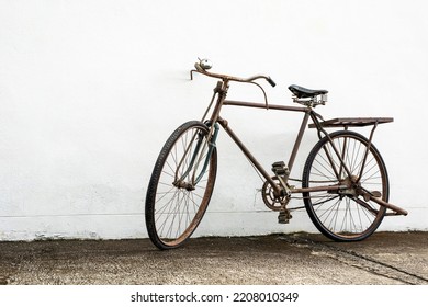 Vintage old bike leaning against white wall background - Powered by Shutterstock