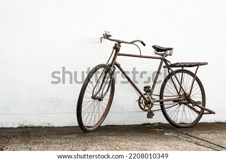 Vintage old bike leaning against white wall background