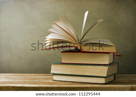 Vintage old books on wooden deck table and grunge background