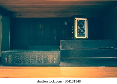 Vintage old camera over stack on books shelf. vintage filter