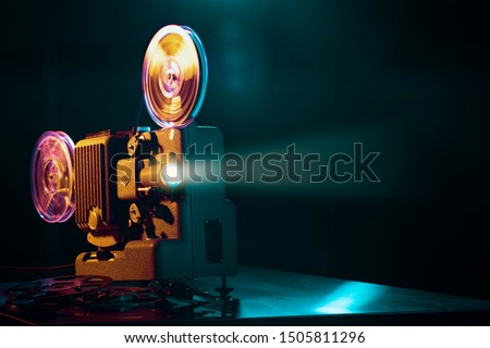 Vintage old fashioned projector in a dark room projecting a film, cinematography concept