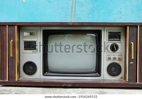 Vintage old
fashioned TV isolated in home. Classic retro style old television
with wooden door open
type.